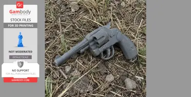 A 3D printed Colt revolver prop lies on grass and dirt, resembling a classic firearm for cosplay use.