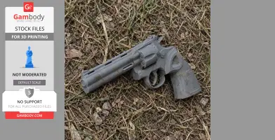 A 3D-printed Colt Python prop gun lies on grass and dirt.