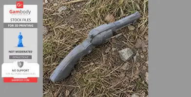 3D printed Colt revolver prop lying on grass and dirt.