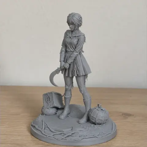 A detailed figurine of a female character holding a sickle, standing on a decorated base with objects.