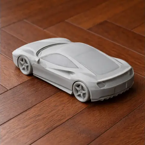 3D-printed model of a sleek sports car, resembling a Ferrari, displayed on a wooden surface.