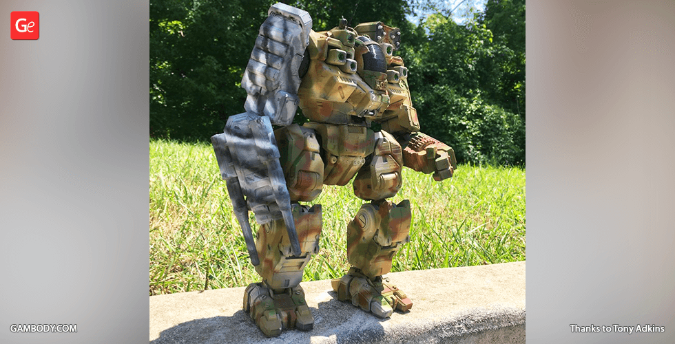 A camouflaged mech figurine from MWO BattleMaster, displayed outdoors on a sunny day.
