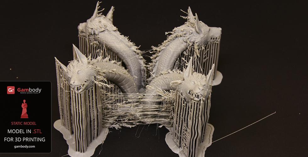 Four dragon-like heads with spiky necks in a 3D printed model, supported by vertical resin structures.