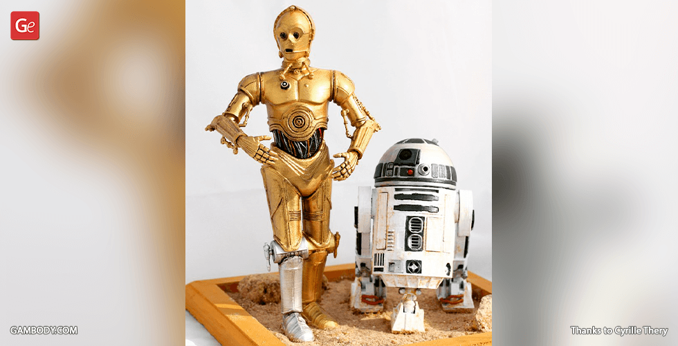 Golden humanoid robot and white astromech droid model on a sandy base.