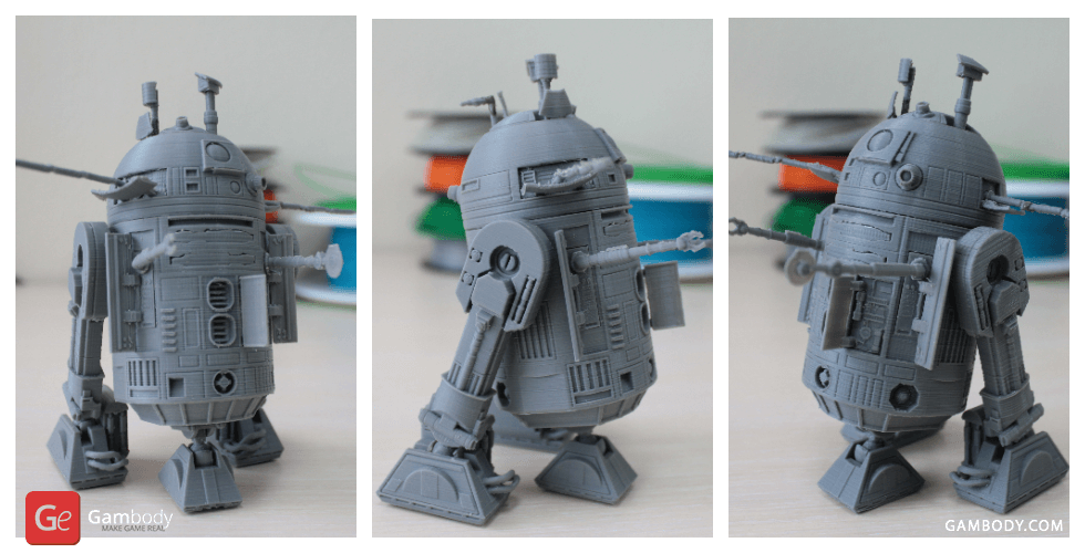 Gray 3D-printed model of a robot with dome head, two legs, and cylindrical body, viewed from three angles.