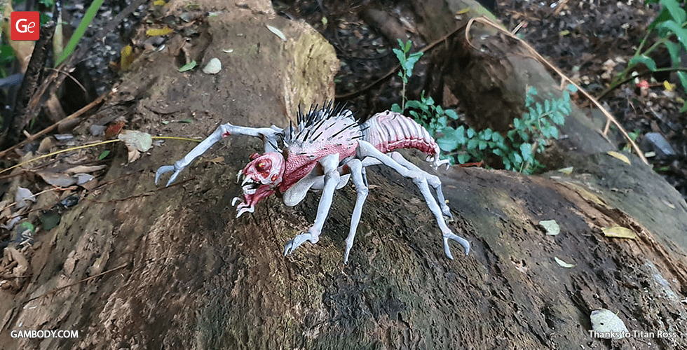 A creepy, detailed spider-like 3D model with pink and white hues on a log in a forest setting.