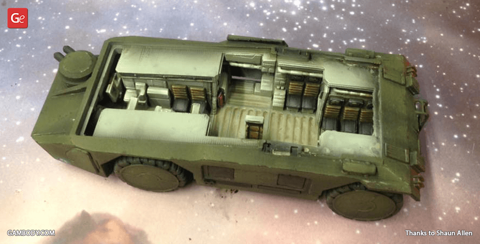 A detailed 3D-printed model of a military armored personnel carrier, with visible interior design.