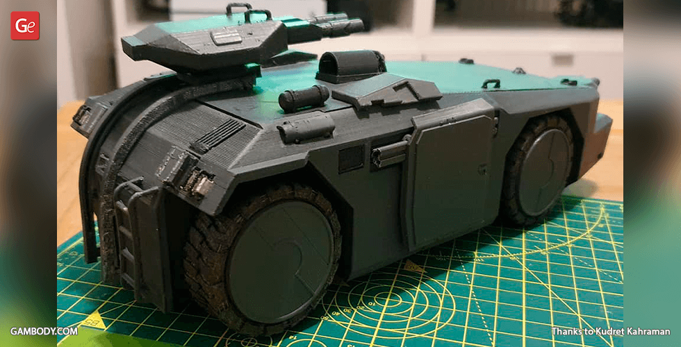 Detailed 3D-printed model of an armored personnel carrier, shown on a cutting mat.